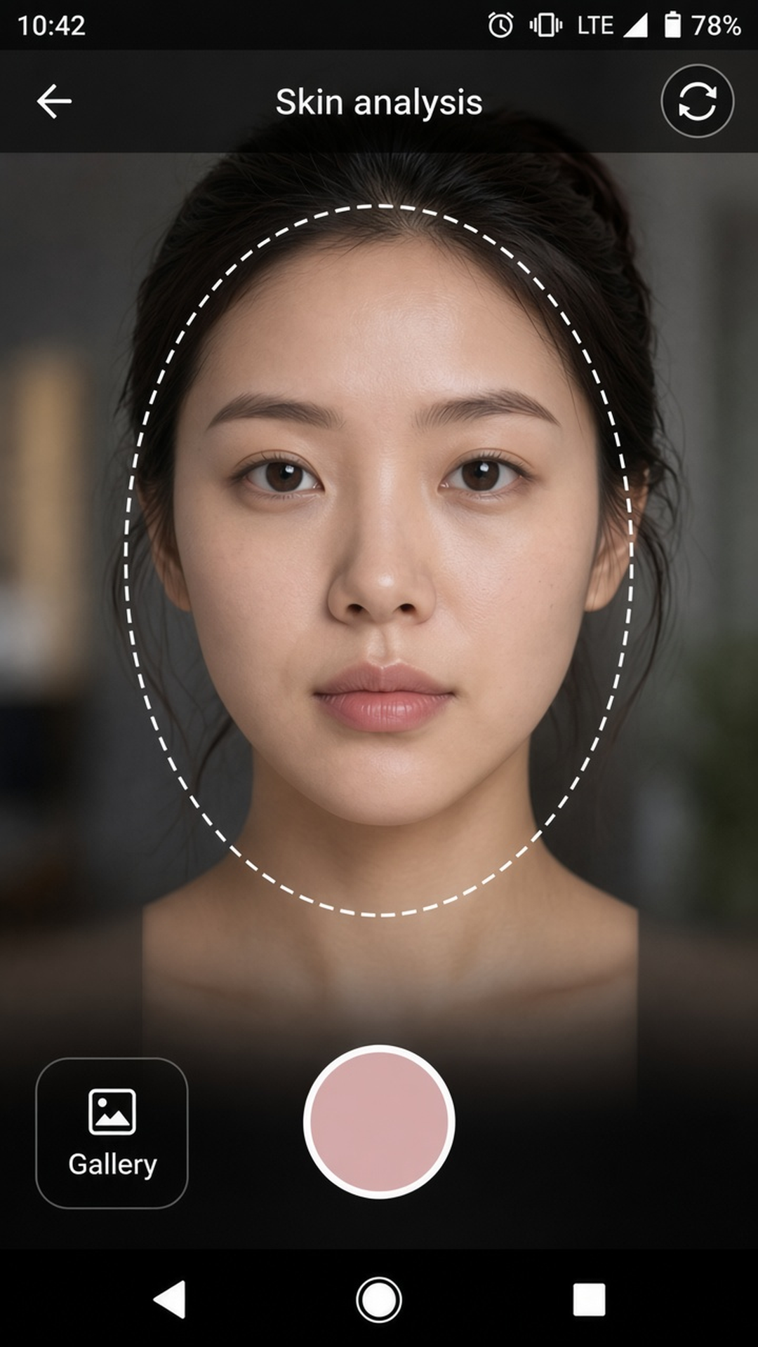 HueSkin camera with a face guide, a gallery button, and a shutter.